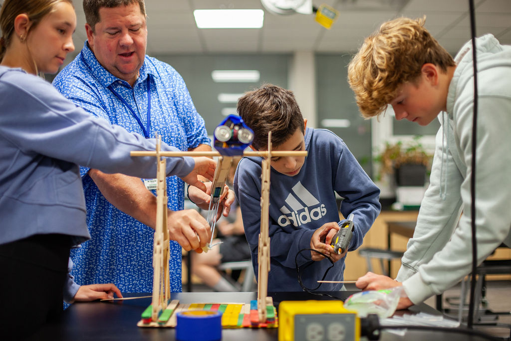 Students and a teaching working on a catapult