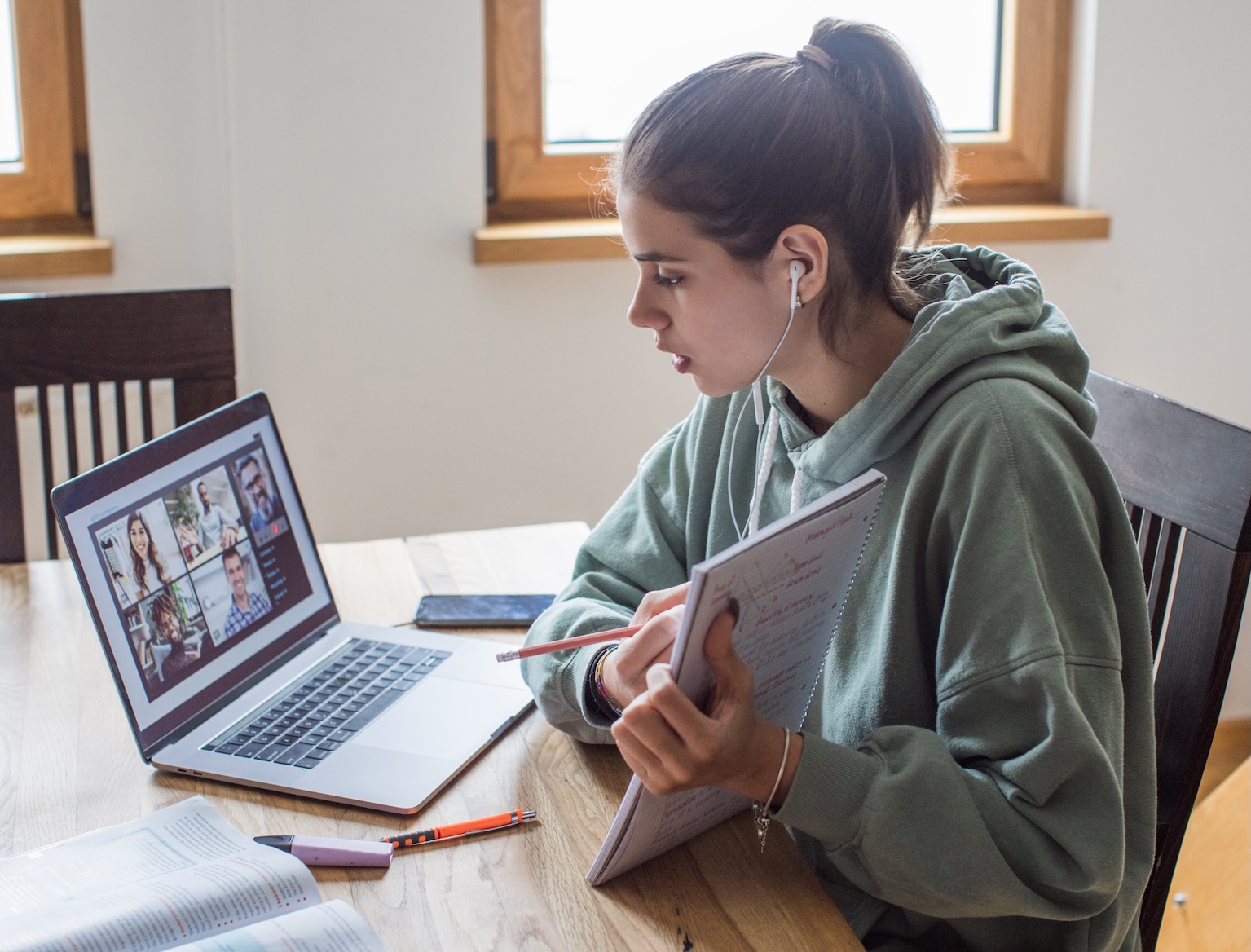 female student with earbuds in showing a presentation on a virtual meeting