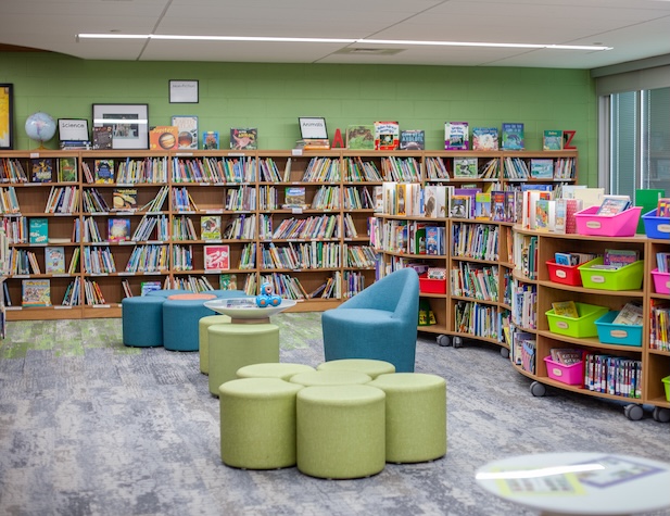 library of books on shelves and chairs